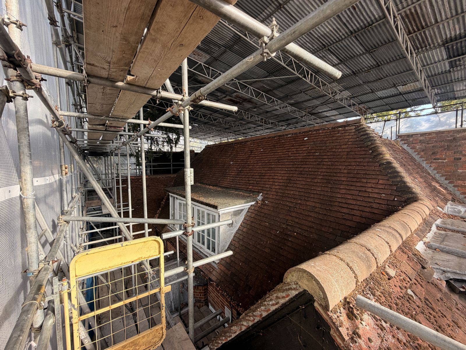 Temporary roof and scaffold enclosing the roof area