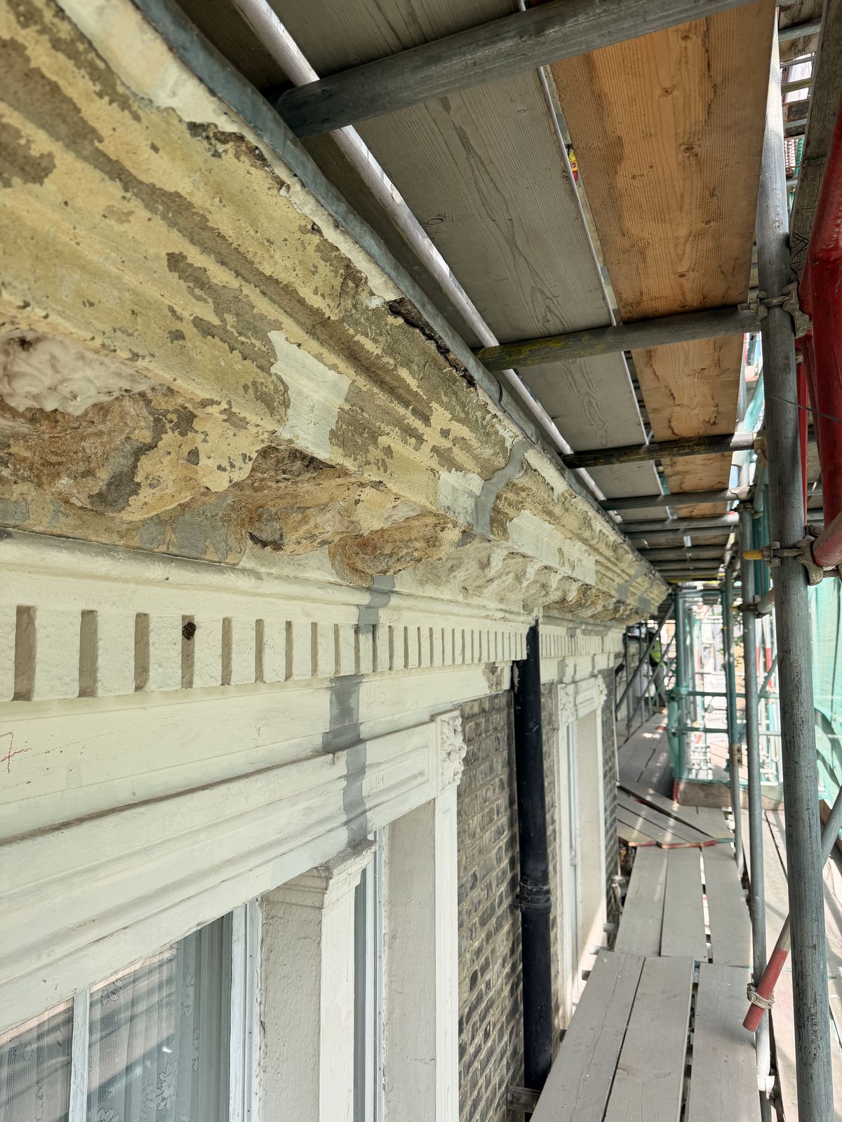 Cornice with modillion brackets showing extensive loss of render